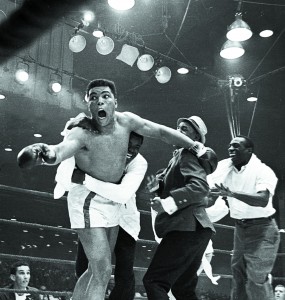 Cassius Clay's handlers hold him back as he reacts after he is announced the new heavyweight champion of the world on a seventh round technical knockout against Sonny Liston at Convention Hall in Miami Beach, Fla., on Feb. 25, 1964. (AP Photo)